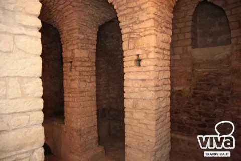 Pilastri in pietra e una nicchia ad arco nella parete dei sotterranei