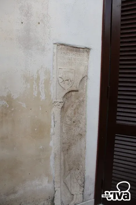 L’altra metà della lastra di sarcofago, con stemma e arco scolpiti, accanto al balcone