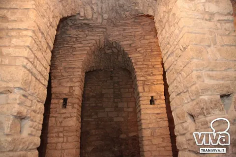 Archi in pietra uno dietro l’altro nei locali sotterranei dell’antica chiesa