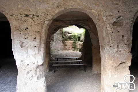 Arcate scavate nel tufo e panche di legno all'interno dell'ipogeo di Santa Geffa