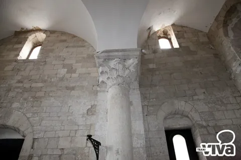 Colonna con capitello a foglie fra due arcate, nelle pareti in pietra a vista della navata