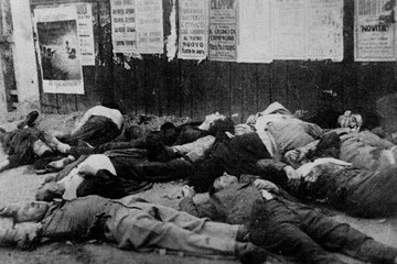 I corpi dei partigiani fucilati a piazzale Loreto il 10 agosto 1944, distesi davanti a uno steccato coperto di manifesti