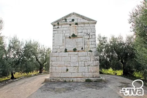 L’epitaffio della Disfida visto di fronte, con le lapidi sulla facciata, fra gli ulivi in fondo a uno spiazzo sterrato