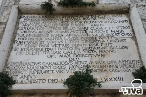 La grande lapide latina del monumento; in basso si legge «Ferdinandus Caracciolus Aerolae dux»