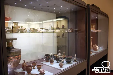 Vetrina della raccolta archeologica con vasi, brocche e ceramiche antiche su due ripiani