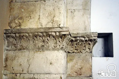 Cornice in pietra scolpita a foglie d'acanto su un pilastro, accanto a una piccola nicchia