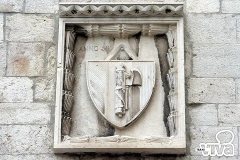 Stemma in pietra con il fascio littorio e la scure, in una cornice scolpita
