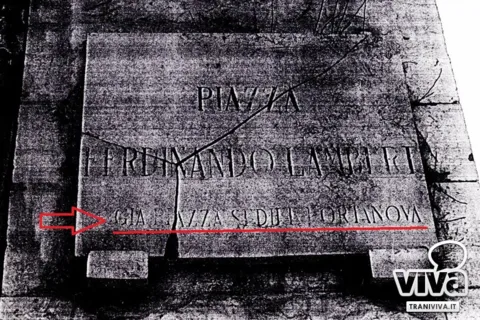Vecchia targa spezzata di piazza Ferdinando Lambert; una freccia rossa indica «già piazza Sedile Portanova»