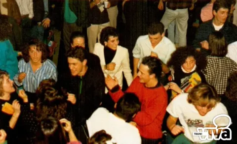 Ragazzi e ragazze sorridenti in una sala affollata, durante una festa