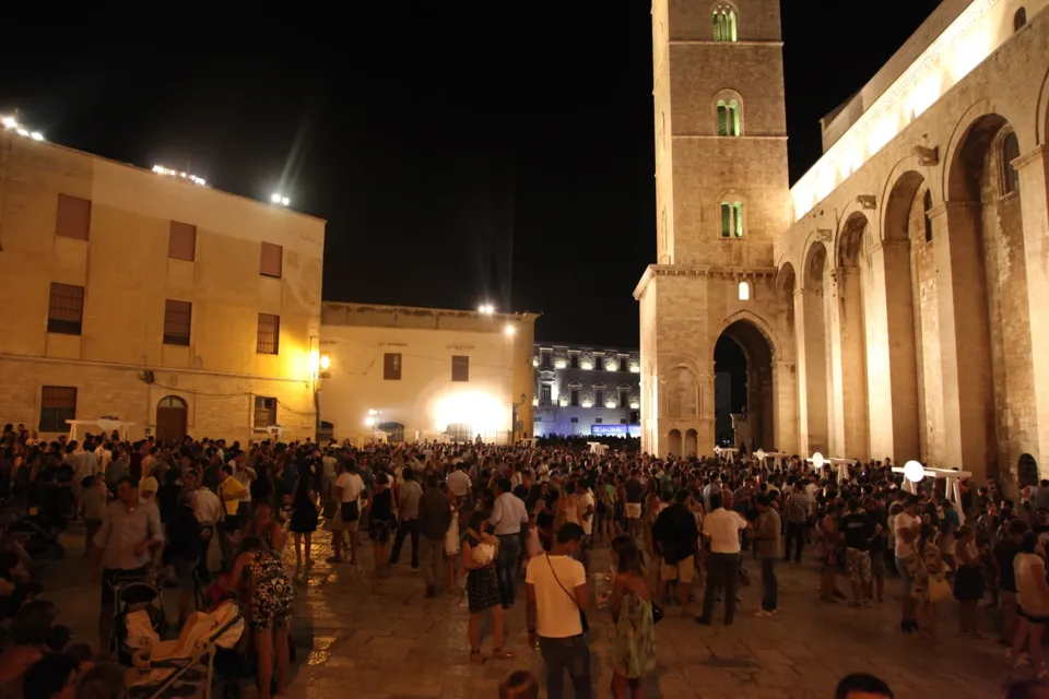 Piazza Duomo affollata di sera durante Calici di Stelle, con il campanile e il fianco della Cattedrale illuminati