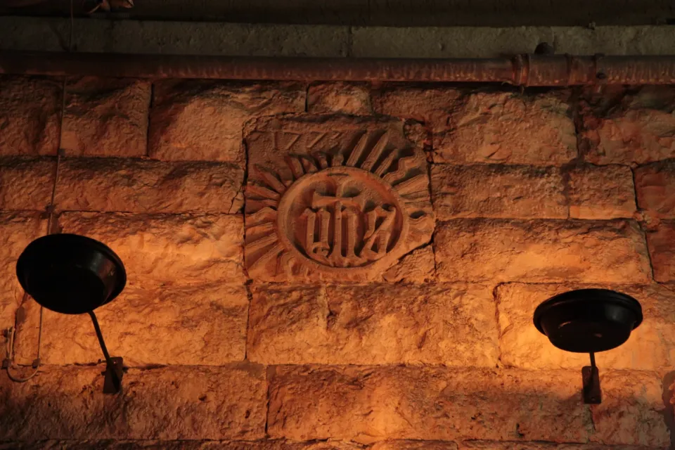 Emblema IHS su muro