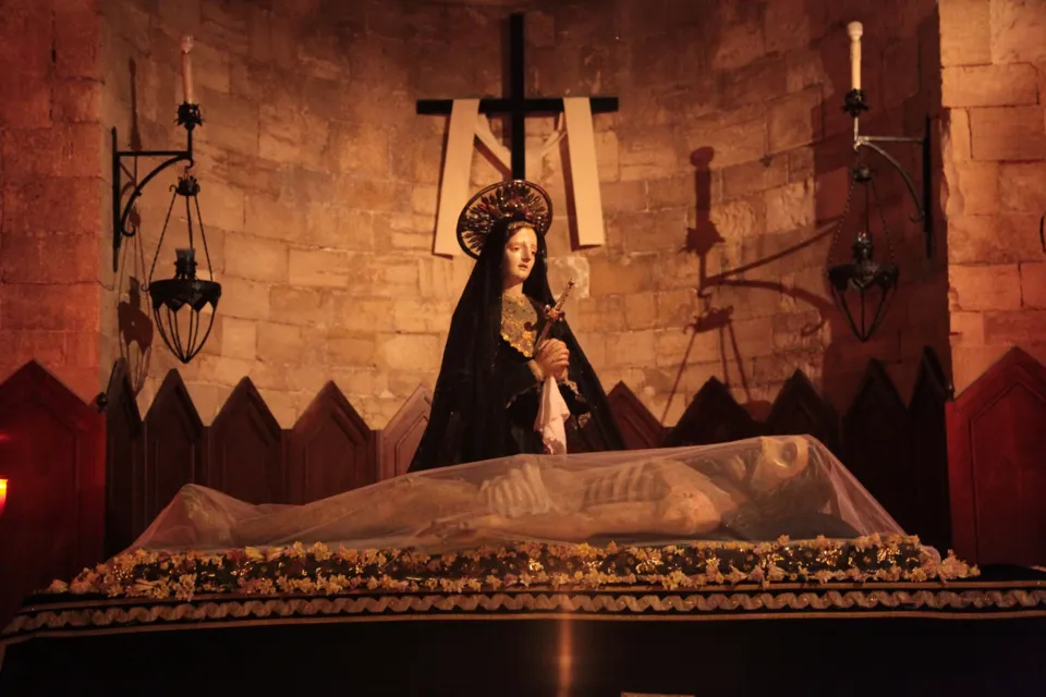 Allestimento del Giovedì Santo con la statua dell'Addolorata davanti al Cristo morto coperto da un velo, sotto una croce con sudario, tra lanterne in ferro