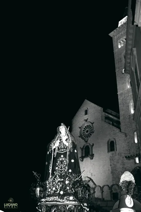 La statua dell'Addolorata in primo piano e, alle spalle, la facciata e il campanile della Cattedrale nella notte
