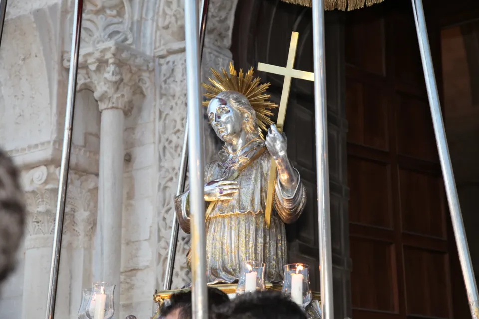 La statua argentea di San Nicola Pellegrino con croce e raggiera esce dal portale della Cattedrale tra le colonne scolpite