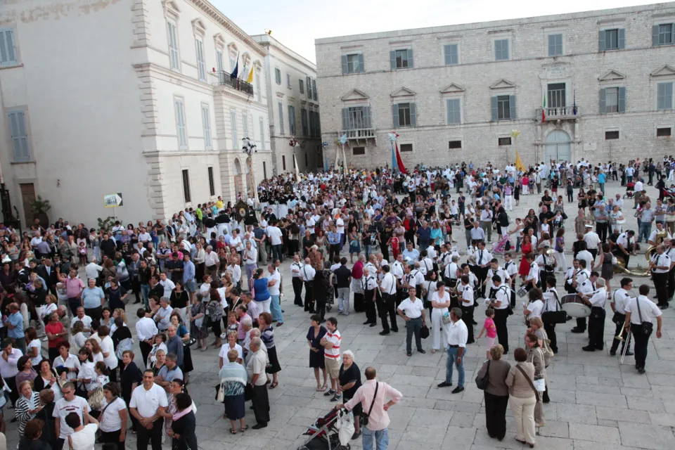 Folla di fedeli e confratelli in piazza Duomo vista dall'alto, in attesa dell'uscita della processione, con i palazzi della piazza sullo sfondo