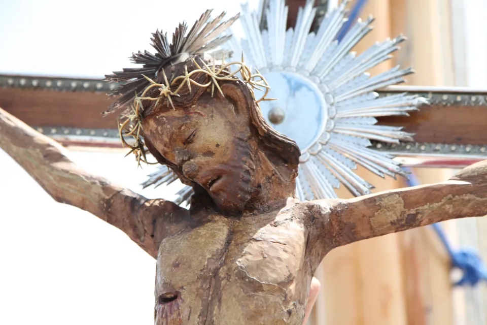 Dettaglio del volto e del busto del Crocifisso ligneo di Colonna con corona di spine metallica e raggiera, in piena luce